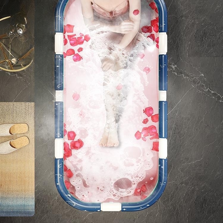 foldable blue bathtub adorned with scattered rose petals